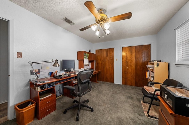 carpeted home office featuring a textured ceiling and ceiling fan