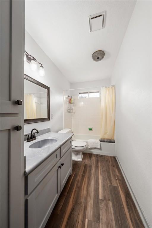 full bathroom with toilet, wood-type flooring, vanity, and shower / tub combo with curtain