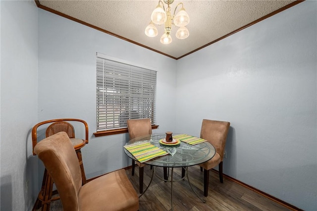 dining space with a textured ceiling, wood-type flooring, crown molding, and a chandelier