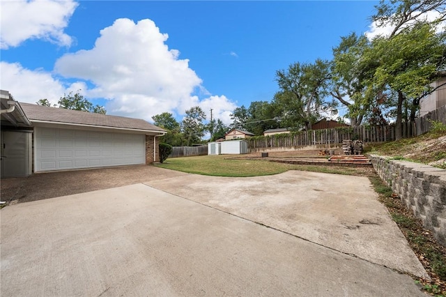 view of yard featuring a garage and a shed