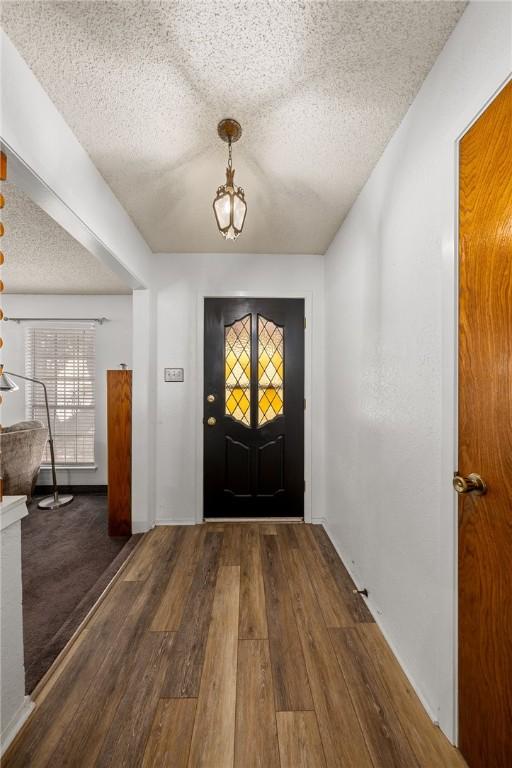 entryway with hardwood / wood-style floors and a textured ceiling