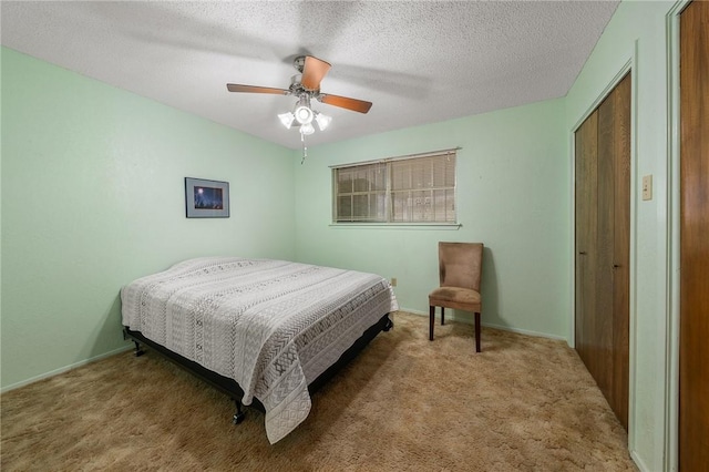 carpeted bedroom with ceiling fan, a closet, and a textured ceiling