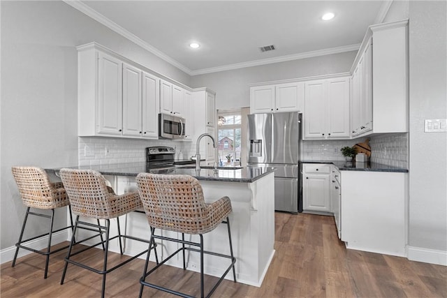 kitchen with white cabinetry, appliances with stainless steel finishes, and kitchen peninsula