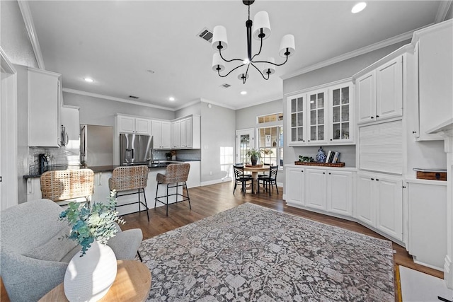 living room featuring ornamental molding, dark hardwood / wood-style floors, and a notable chandelier