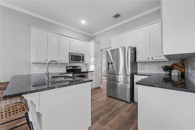 kitchen featuring stainless steel appliances, white cabinetry, sink, and kitchen peninsula