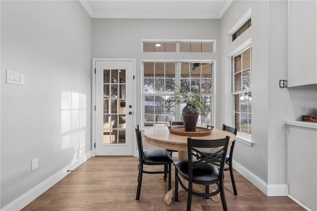 dining area featuring wood-type flooring and ornamental molding