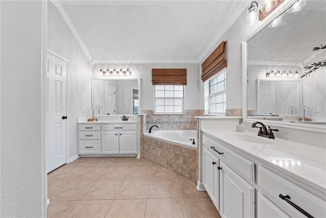 bathroom featuring tile patterned flooring, tiled tub, crown molding, and vanity