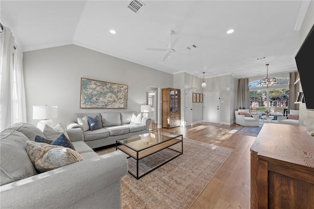 living room featuring ornamental molding, lofted ceiling, ceiling fan, and light hardwood / wood-style flooring