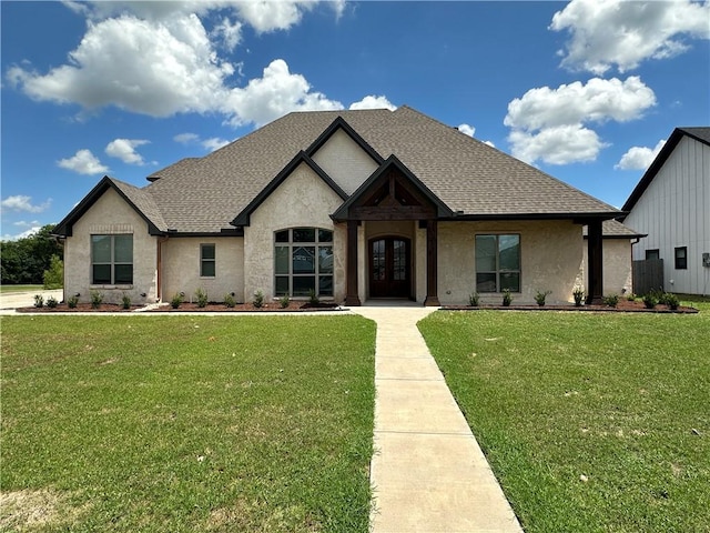 french provincial home featuring a front yard and french doors