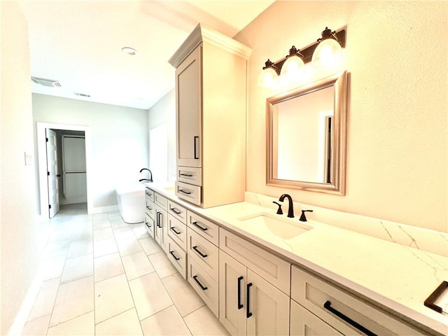 bathroom featuring tile patterned floors, a washtub, and vanity