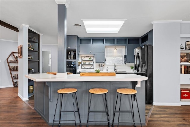 kitchen with a kitchen breakfast bar, a center island, and dark hardwood / wood-style flooring