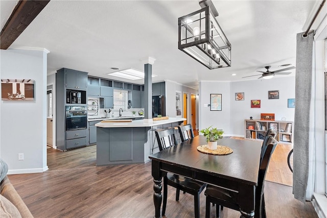 dining room featuring hardwood / wood-style flooring, ceiling fan, sink, and crown molding