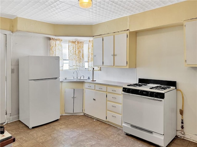 kitchen with white cabinetry, sink, and white appliances