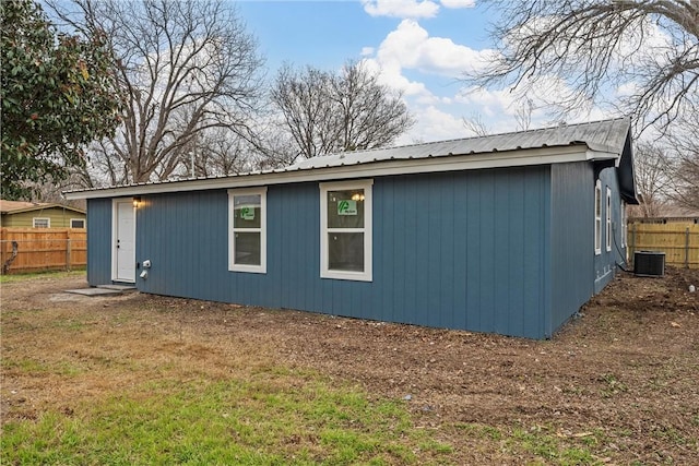 view of side of property featuring a yard and central AC