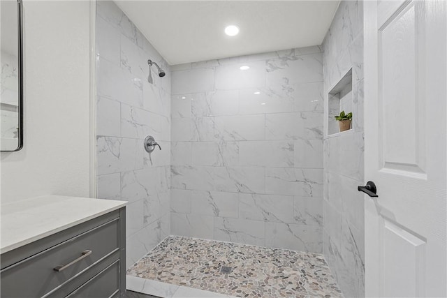 bathroom with vanity and tiled shower