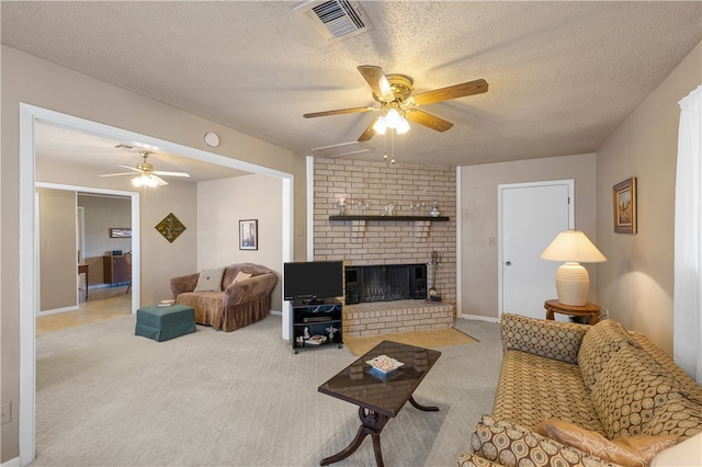 carpeted living room featuring ceiling fan, a textured ceiling, and a fireplace