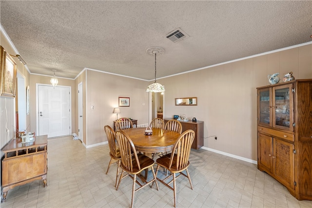 dining area with ornamental molding and a textured ceiling