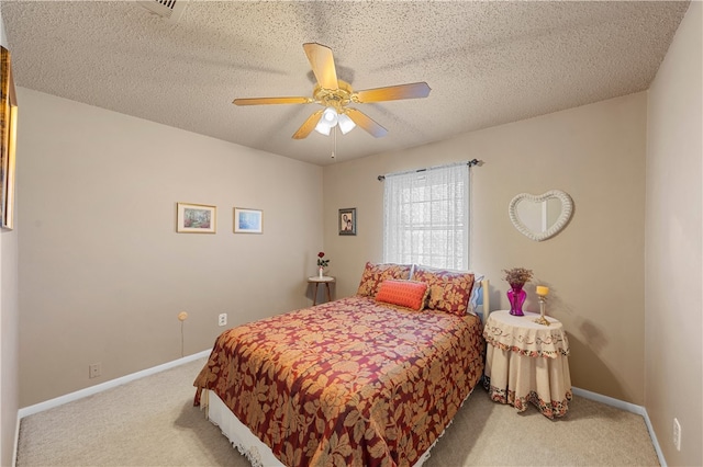 bedroom featuring ceiling fan, light colored carpet, and a textured ceiling