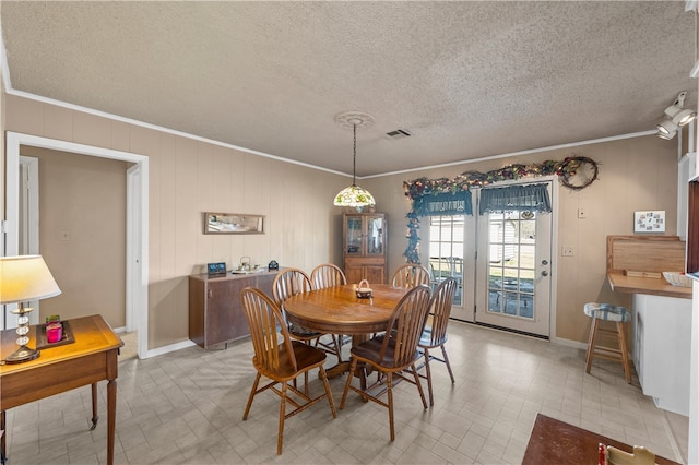 dining room featuring ornamental molding and a textured ceiling