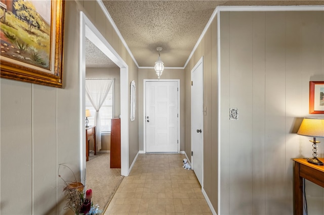 hallway with ornamental molding and a textured ceiling