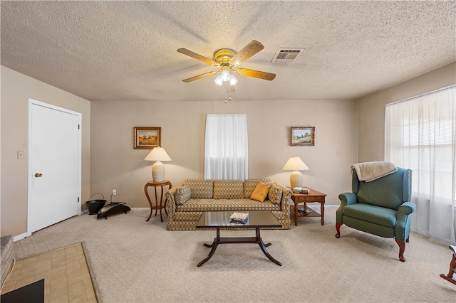 living room with a textured ceiling, ceiling fan, and carpet