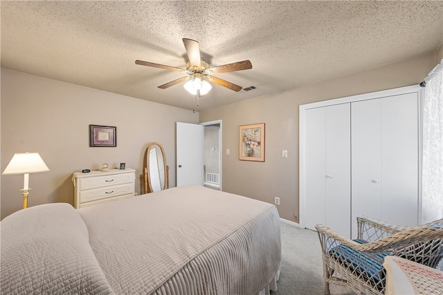 bedroom with ceiling fan, light colored carpet, a textured ceiling, and a closet