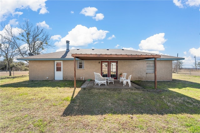 back of house featuring french doors, a patio area, and a lawn