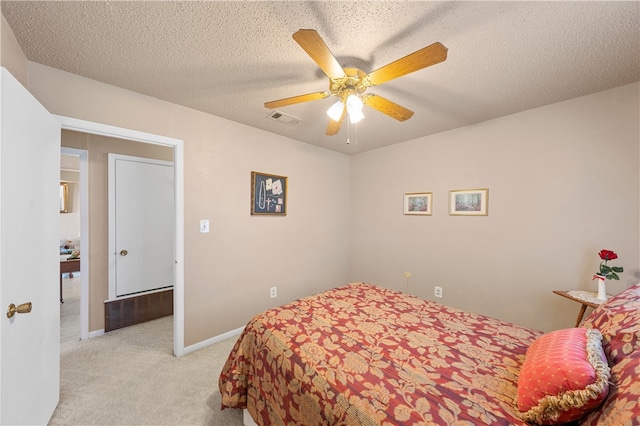 carpeted bedroom with ceiling fan and a textured ceiling