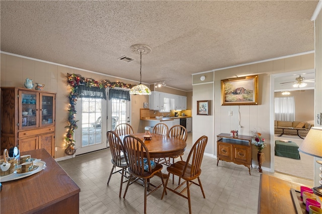 dining space with ornamental molding and a textured ceiling