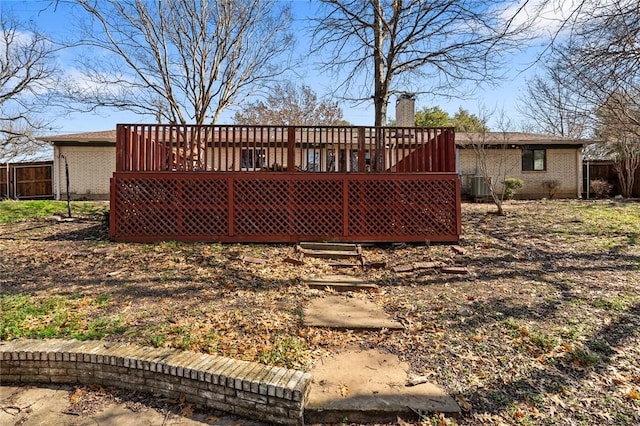 rear view of property with a wooden deck and cooling unit