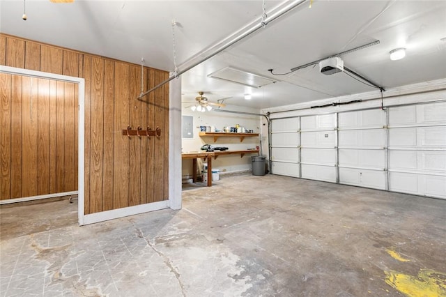 garage featuring a garage door opener, electric panel, and wood walls