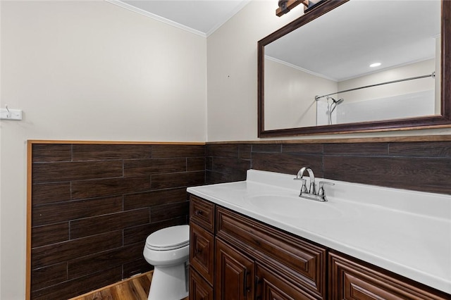 bathroom with toilet, wood-type flooring, tile walls, ornamental molding, and vanity