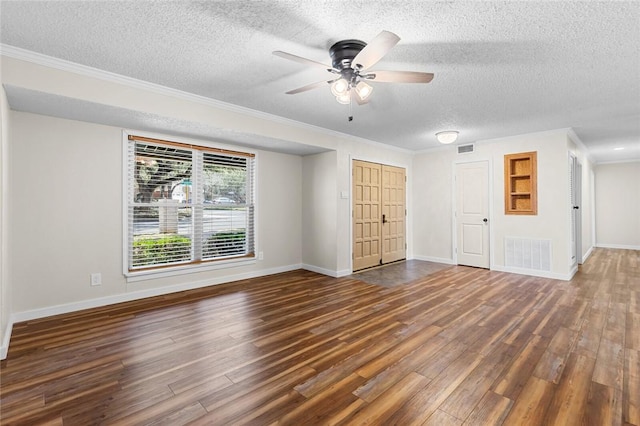 spare room with dark hardwood / wood-style flooring, a textured ceiling, ornamental molding, and ceiling fan