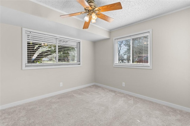 spare room with crown molding, light colored carpet, ceiling fan, and a textured ceiling