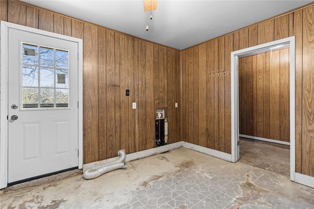 doorway to outside with wood walls