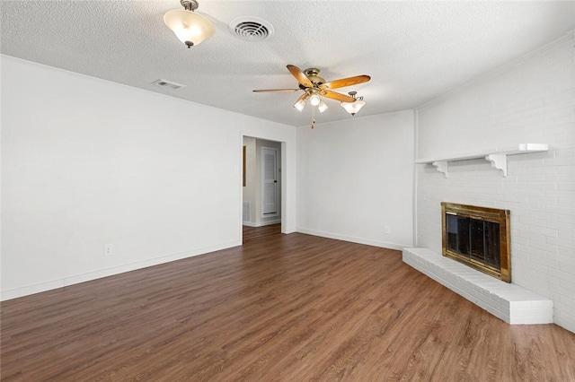 unfurnished living room with dark wood-type flooring, a fireplace, a textured ceiling, and ceiling fan