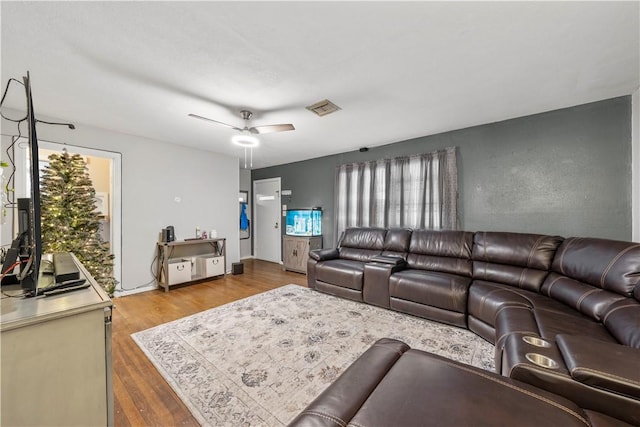 living room featuring ceiling fan, plenty of natural light, and hardwood / wood-style flooring