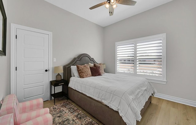 bedroom featuring a ceiling fan, baseboards, and wood finished floors