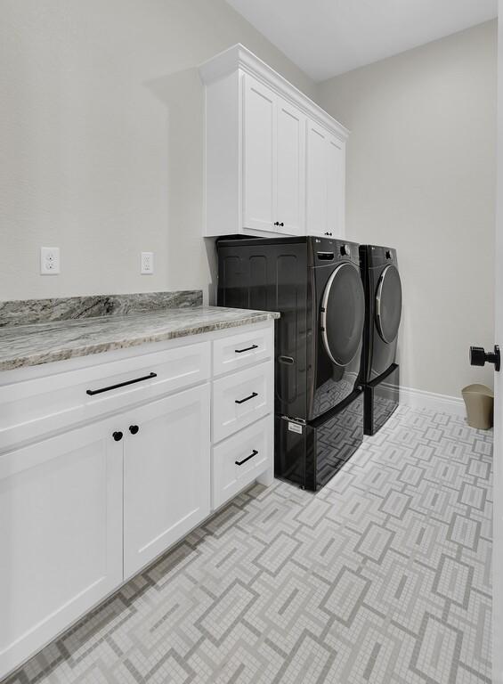 laundry room with washer and clothes dryer, cabinet space, and baseboards