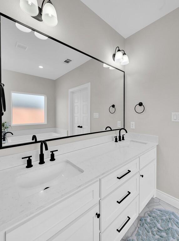 bathroom with double vanity, visible vents, marble finish floor, and a sink