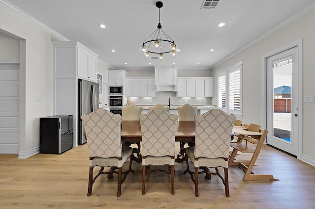 kitchen featuring visible vents, a sink, freestanding refrigerator, crown molding, and built in microwave