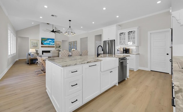 kitchen featuring visible vents, an island with sink, a fireplace, ceiling fan, and stainless steel appliances