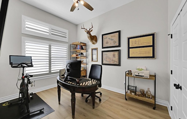 office featuring baseboards, a ceiling fan, and light wood finished floors