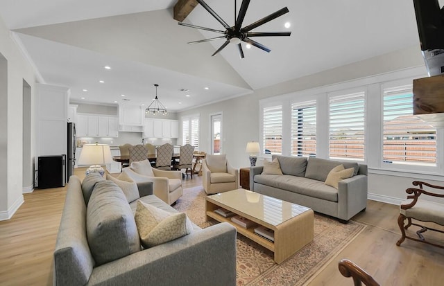 living room with baseboards, beamed ceiling, ornamental molding, light wood-style floors, and high vaulted ceiling