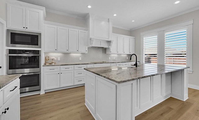 kitchen with built in microwave, ornamental molding, double oven, and a sink