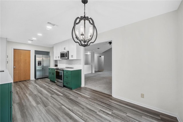 kitchen featuring appliances with stainless steel finishes, tasteful backsplash, decorative light fixtures, white cabinetry, and green cabinets