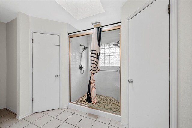 bathroom featuring tile patterned floors and a tile shower