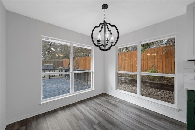 unfurnished dining area featuring hardwood / wood-style floors and an inviting chandelier