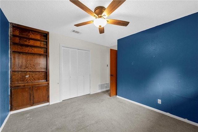 unfurnished bedroom featuring carpet flooring, ceiling fan, and a closet