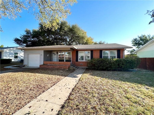 ranch-style house with a garage, brick siding, fence, and a front lawn